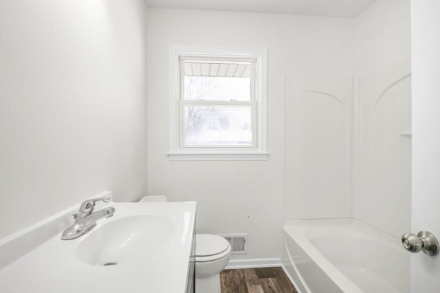 full bathroom with visible vents, toilet, vanity, wood finished floors, and baseboards