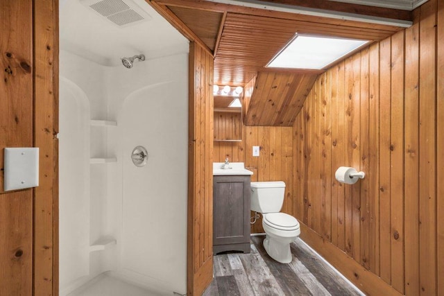 full bathroom featuring toilet, a skylight, wood finished floors, visible vents, and walk in shower