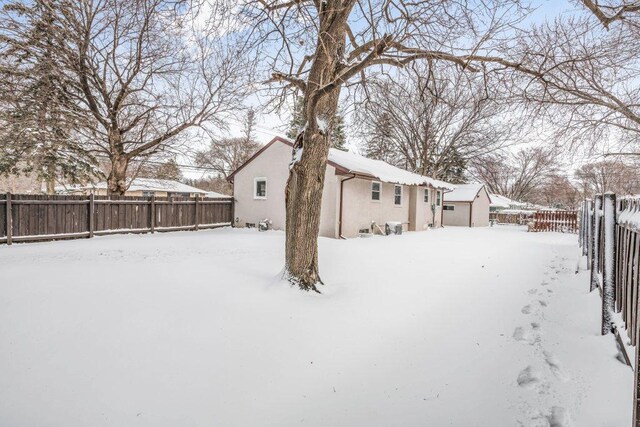 yard layered in snow featuring a fenced backyard