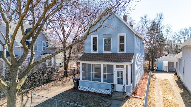 traditional-style home featuring entry steps, fence private yard, a sunroom, and a shingled roof