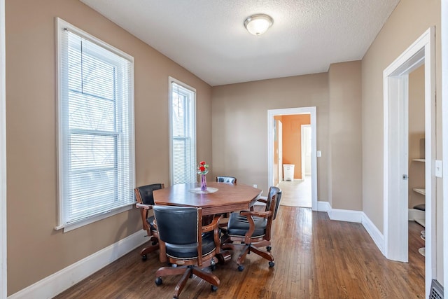 dining area with visible vents, wood finished floors, baseboards, and a textured ceiling