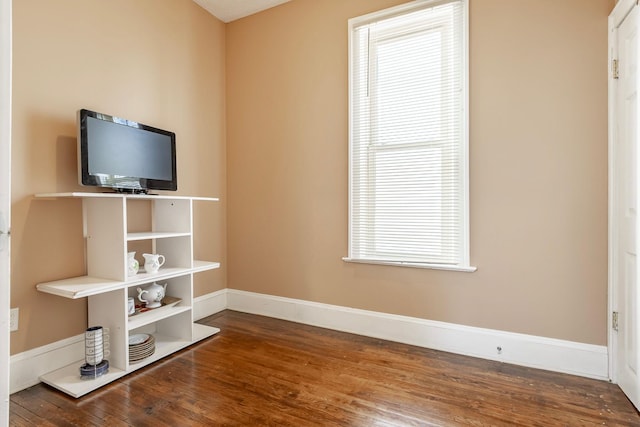 interior space with wood finished floors and baseboards