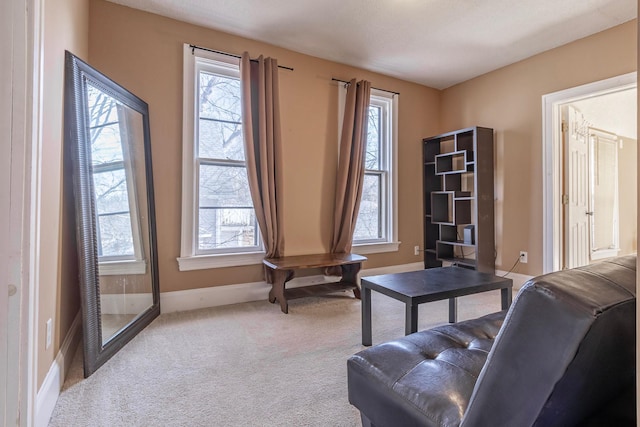 living area with carpet flooring, baseboards, and a wealth of natural light