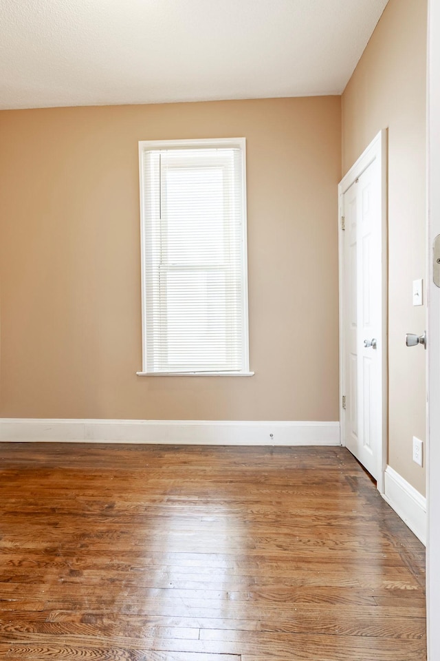 empty room with wood finished floors and baseboards