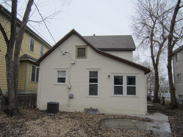 back of property with a shingled roof and stucco siding