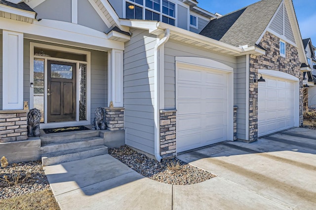 property entrance featuring a garage, stone siding, driveway, and roof with shingles