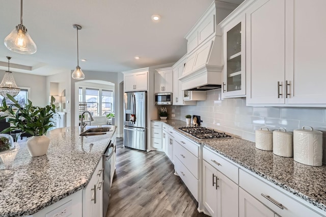 kitchen with white cabinetry, appliances with stainless steel finishes, decorative backsplash, and a sink