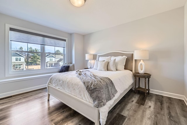 bedroom featuring visible vents, baseboards, and wood finished floors