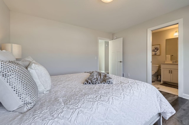 bedroom featuring a sink, wood finished floors, and ensuite bathroom