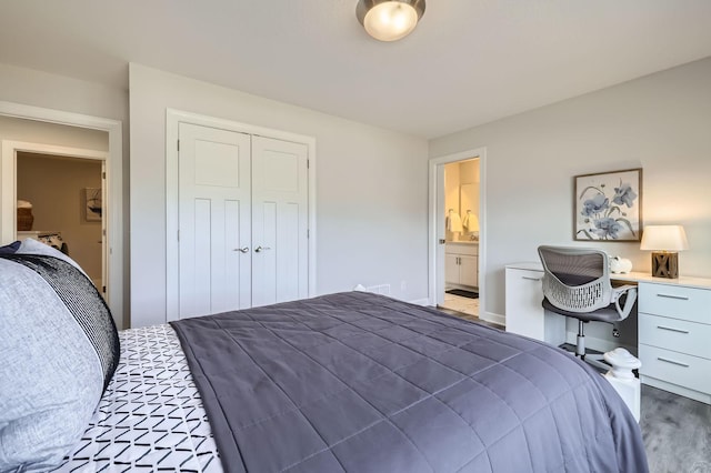 bedroom featuring ensuite bath, a closet, and wood finished floors