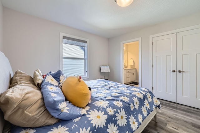 bedroom featuring a closet, wood finished floors, and ensuite bathroom