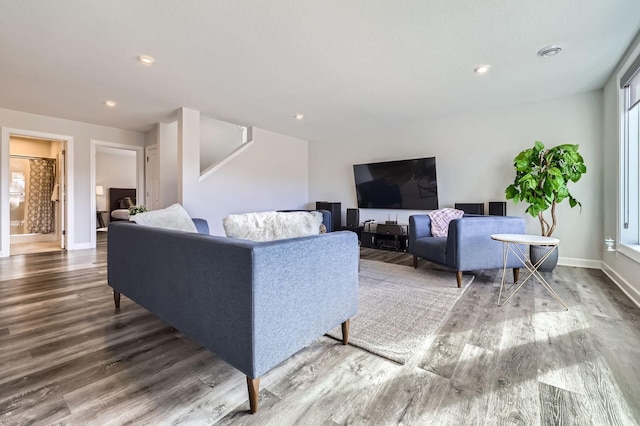 living area featuring baseboards, wood finished floors, and recessed lighting