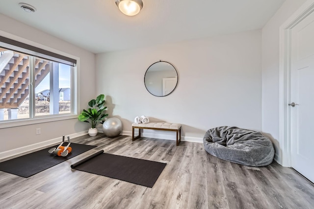 workout room with visible vents, baseboards, and wood finished floors