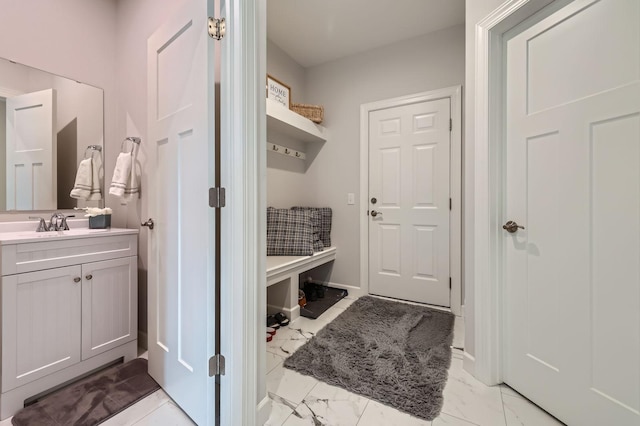 mudroom featuring marble finish floor and a sink