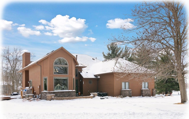 snow covered property featuring a chimney