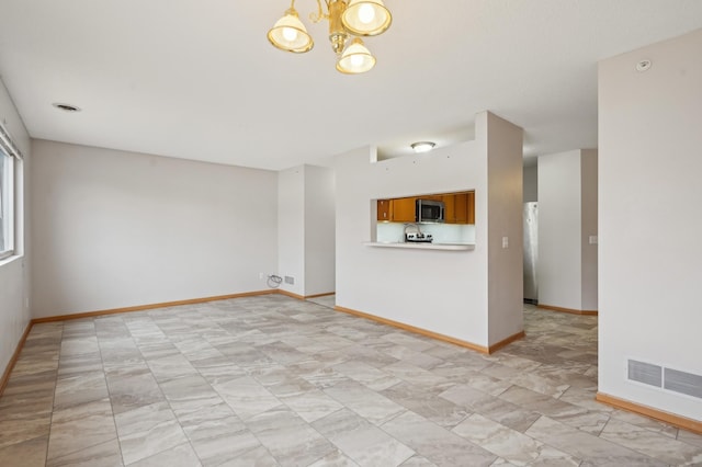 unfurnished room featuring a notable chandelier, visible vents, and baseboards