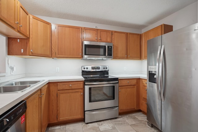 kitchen featuring appliances with stainless steel finishes, brown cabinets, and light countertops