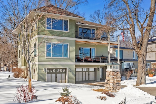 view of front of home featuring an attached garage and a balcony