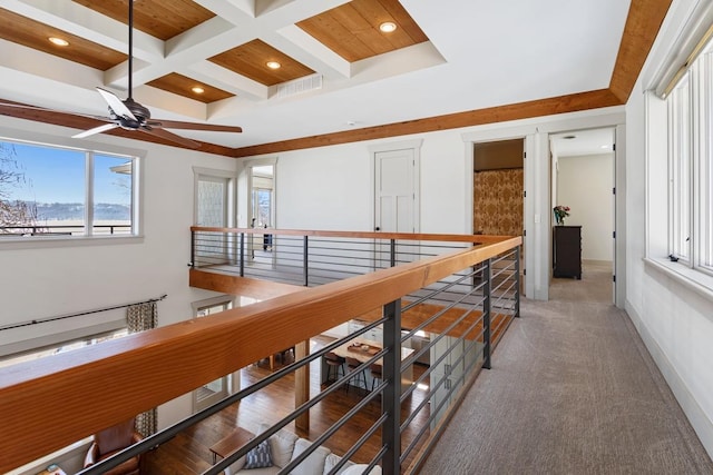 hall with beam ceiling, coffered ceiling, an upstairs landing, and baseboards