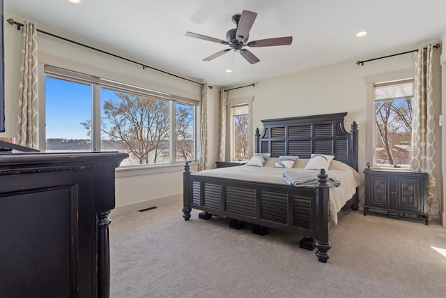 carpeted bedroom featuring baseboards, multiple windows, visible vents, and recessed lighting