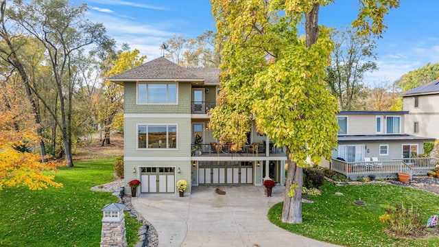 view of front of house featuring a carport, a front yard, a balcony, a garage, and driveway