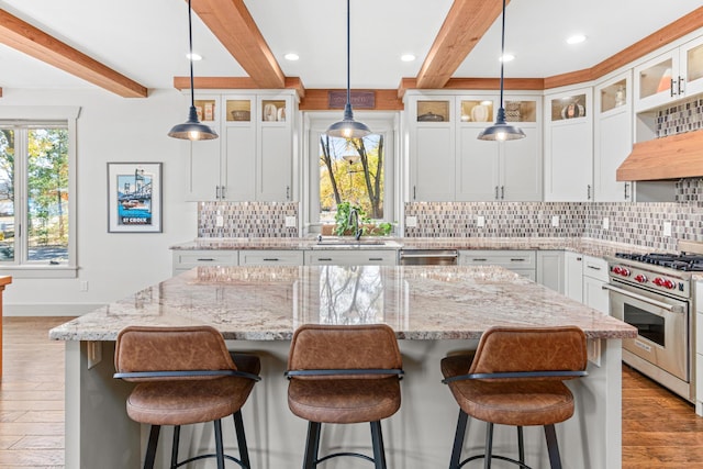 kitchen featuring appliances with stainless steel finishes, a sink, beam ceiling, and a healthy amount of sunlight