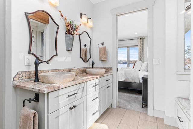 full bath featuring double vanity, tile patterned floors, a sink, and ensuite bathroom