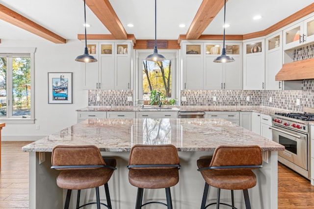 kitchen with beam ceiling, appliances with stainless steel finishes, decorative backsplash, and a sink
