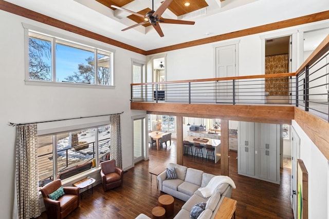 living room with coffered ceiling, a ceiling fan, hardwood / wood-style floors, and beamed ceiling