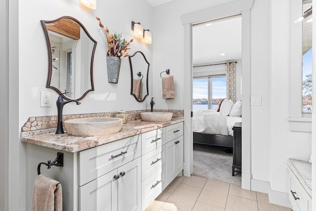 full bath featuring tile patterned floors, ensuite bathroom, a sink, and double vanity