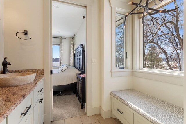 full bath with connected bathroom, vanity, and tile patterned floors