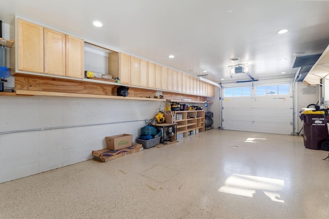 garage with recessed lighting and a garage door opener