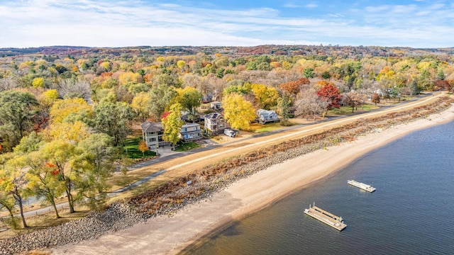 birds eye view of property featuring a forest view and a water view