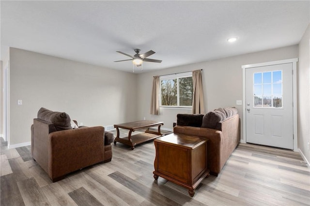 living area with light wood-type flooring and baseboards