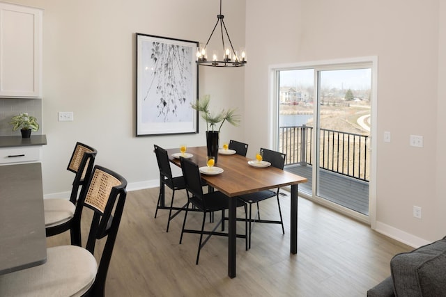 dining area with a notable chandelier, baseboards, and wood finished floors