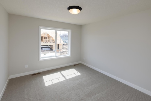 carpeted empty room with baseboards and visible vents