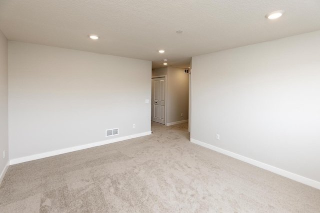 unfurnished room featuring visible vents, baseboards, light carpet, recessed lighting, and a textured ceiling