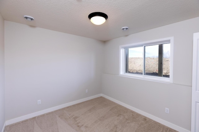 unfurnished room featuring baseboards, carpet floors, and a textured ceiling