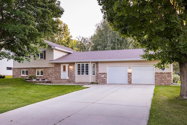 tri-level home featuring a garage, a front lawn, concrete driveway, and brick siding