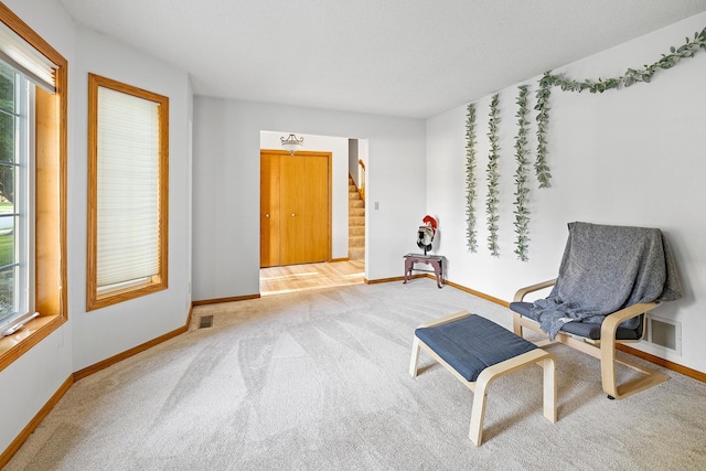 sitting room featuring carpet, stairs, baseboards, and visible vents