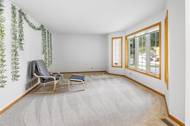 unfurnished room with baseboards, visible vents, and carpet flooring