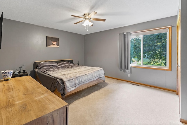 carpeted bedroom featuring visible vents, ceiling fan, a textured ceiling, and baseboards