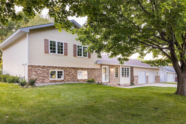 split level home with concrete driveway, brick siding, an attached garage, and a front lawn