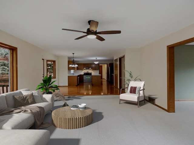 living area with a ceiling fan, carpet flooring, and baseboards