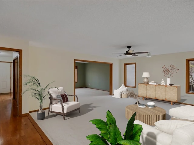 living area featuring ceiling fan, a textured ceiling, wood finished floors, and baseboards