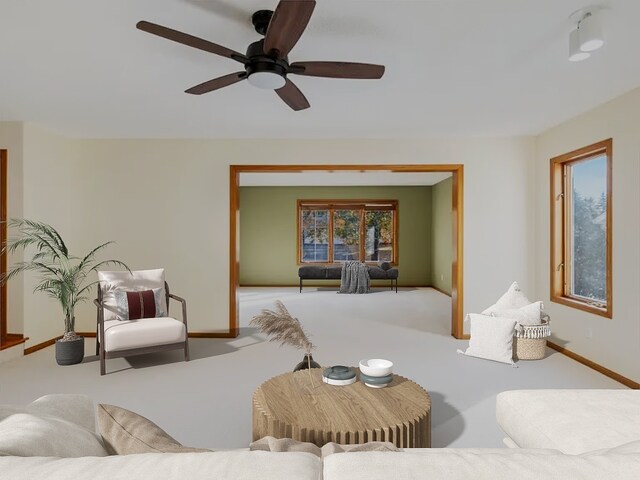 carpeted living area featuring a ceiling fan and baseboards