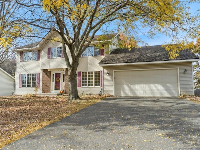 colonial-style house featuring a garage and driveway