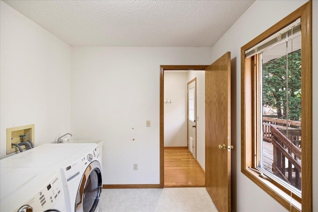 clothes washing area featuring laundry area, baseboards, washer and clothes dryer, a textured ceiling, and a sink