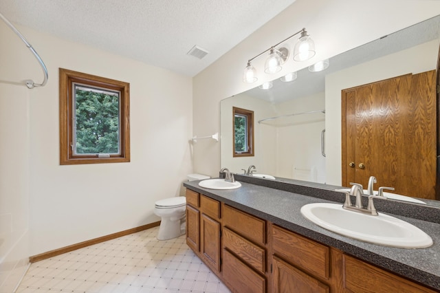 full bathroom featuring toilet, a textured ceiling, visible vents, and a sink