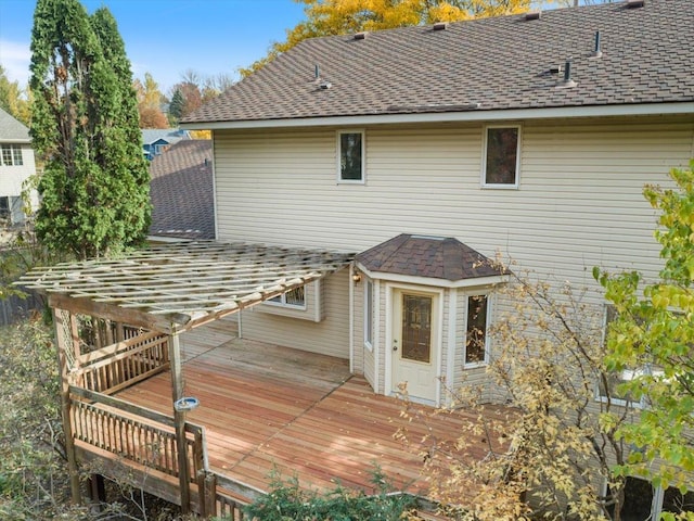 back of house featuring a shingled roof and a deck